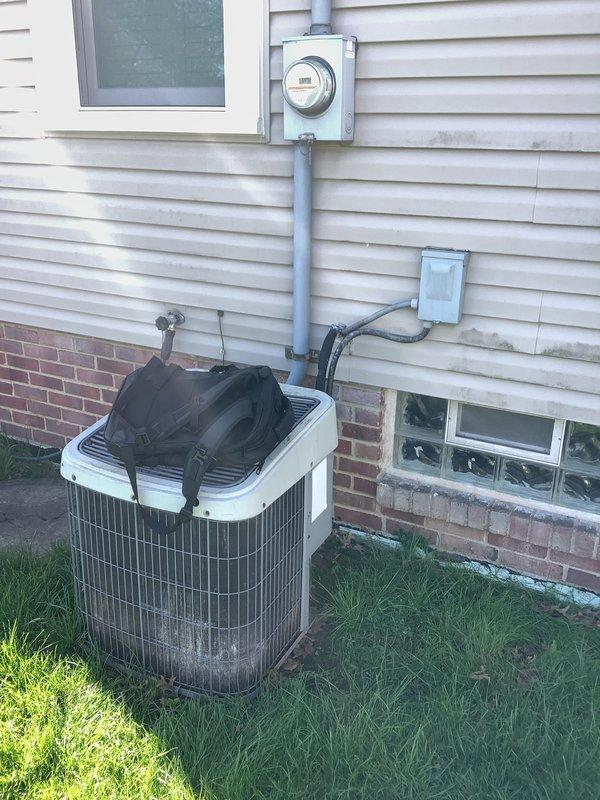 Conducted comprehensive on-site evaluation for complete HVAC system replacement following reported lightning strike and power surge damage. Assessed existing indoor furnace unit with associated ductwork, plenum assembly, and refrigerant line connections in mechanical space. Evaluated outdoor cylindrical condenser unit positioned at foundation level with existing electrical service and conduit routing. Documented current system configuration including copper refrigerant lines, electrical disconnect components, and meter connections. Prepared detailed replacement estimate to match specifications from competing proposal for insurance claim processing related to storm damage.