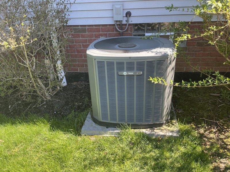Completed comprehensive assessment of existing residential HVAC system for replacement estimate on large home exceeding 3000 square feet. Evaluated current basement-installed natural gas furnace with associated PVC venting, condensate drainage system, and electrical connections, as well as outdoor Trane air conditioning unit positioned on concrete pad against building exterior. Documented equipment specifications, installation configuration, and spatial requirements to provide accurate replacement recommendations for complete heating and cooling system upgrade.