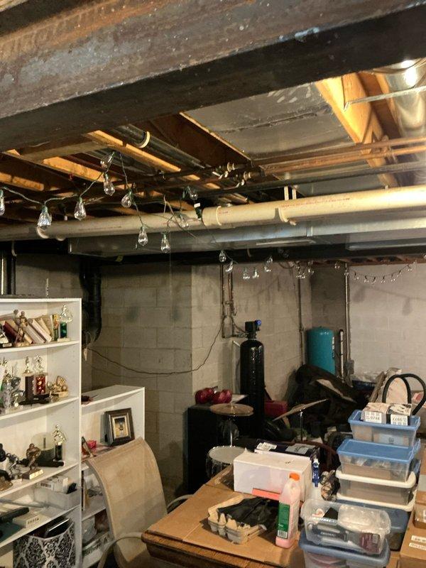 # Electrical Estimate - Generator Installation

Conducted comprehensive site assessment for Kohler generator installation at residential property. Evaluated basement utility area to determine optimal routing for electrical connections, noting existing overhead utilities including ductwork, plumbing lines, and electrical runs along floor joists. Assessed concrete block wall construction and available clearances for potential transfer switch and control panel mounting locations.

Inspected exterior electrical service entrance and metering equipment to determine connection requirements for automatic transfer switch integration with existing 200-amp service panel. Documented current utility connections including gas line infrastructure with shutoff valve and pressure regulation equipment mounted on exterior wall above brick foundation. Evaluated exterior mounting location adjacent to existing utilities, confirming adequate clearances from windows, venting systems, and property structures p