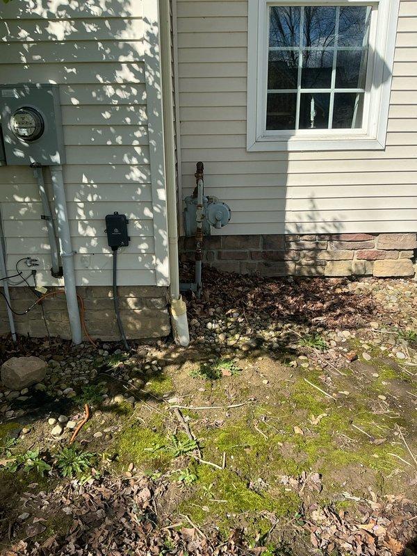 # Electrical Estimate - Generator Installation

Conducted comprehensive site assessment for Kohler generator installation at residential property. Evaluated basement utility area to determine optimal routing for electrical connections, noting existing overhead utilities including ductwork, plumbing lines, and electrical runs along floor joists. Assessed concrete block wall construction and available clearances for potential transfer switch and control panel mounting locations.

Inspected exterior electrical service entrance and metering equipment to determine connection requirements for automatic transfer switch integration with existing 200-amp service panel. Documented current utility connections including gas line infrastructure with shutoff valve and pressure regulation equipment mounted on exterior wall above brick foundation. Evaluated exterior mounting location adjacent to existing utilities, confirming adequate clearances from windows, venting systems, and property structures p