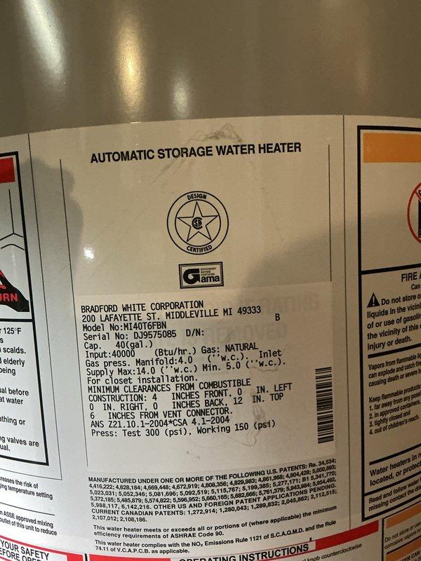 Responded to service call for 18-year-old Bradford White 40-gallon natural gas water heater (Model MI40T6FBN) experiencing leaks from two separate locations on the tank. Upon inspection, documented the condition of the unit installed in basement crawl space area and confirmed active leaking from the tank body, which is typical of tank failure due to internal corrosion at this age. Photographed the water heater specifications and installation environment showing the unit's connection to existing gas and water supply lines, as well as the surrounding utility infrastructure including copper piping, black gas line, and PVC drainage.
