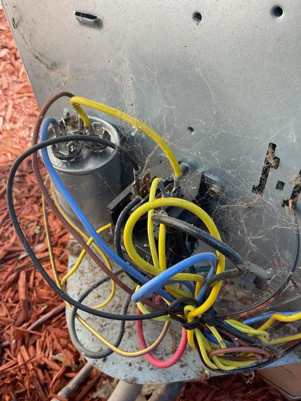 Responded to emergency water leak call for 52-year-old HVAC system with condenser and air handler located in attic space. Upon arrival, accessed attic-mounted equipment and performed thorough inspection of air handler, condensate drain system, and associated piping. Identified active water leak originating from primary drain line connection at air handler, which had caused water damage to living room ceiling below. Cleared clogged condensate drain line, repaired loose drain connection, and verified proper drainage flow. Inspected evaporator coil and drain pan for additional issues, finding drain pan showed signs of age-related deterioration. Tested system operation and monitored for proper condensate removal. Documented equipment condition with photos showing outdoor condenser unit and internal components including capacitor and wiring connections. Advised that system age and attic installation may require future maintenance attention, particularly regarding condensate management and p