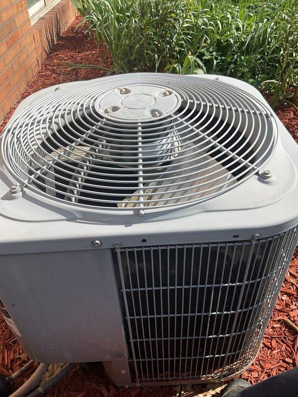 Responded to emergency water leak call for 52-year-old HVAC system with condenser and air handler located in attic space. Upon arrival, accessed attic-mounted equipment and performed thorough inspection of air handler, condensate drain system, and associated piping. Identified active water leak originating from primary drain line connection at air handler, which had caused water damage to living room ceiling below. Cleared clogged condensate drain line, repaired loose drain connection, and verified proper drainage flow. Inspected evaporator coil and drain pan for additional issues, finding drain pan showed signs of age-related deterioration. Tested system operation and monitored for proper condensate removal. Documented equipment condition with photos showing outdoor condenser unit and internal components including capacitor and wiring connections. Advised that system age and attic installation may require future maintenance attention, particularly regarding condensate management and p