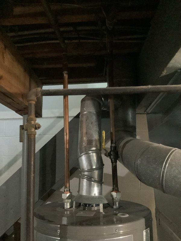 Responded to service call for water heater repair at residential property. Upon arrival, performed comprehensive inspection of tanked water heater unit located in basement mechanical room. Assessed water heater condition, examined all visible connections including copper supply lines and galvanized steel piping, and evaluated overall system performance. Inspected top-mounted pipe connections, pressure relief valve, and related plumbing infrastructure. Verified proper clearances around unit and checked for any signs of leakage or corrosion on tank surface and pipe connections. Documented existing installation with photographs showing water heater positioned adjacent to HVAC furnace system with connected ductwork. Completed necessary repairs to restore water heater to proper working condition and applied promotional discount as requested.