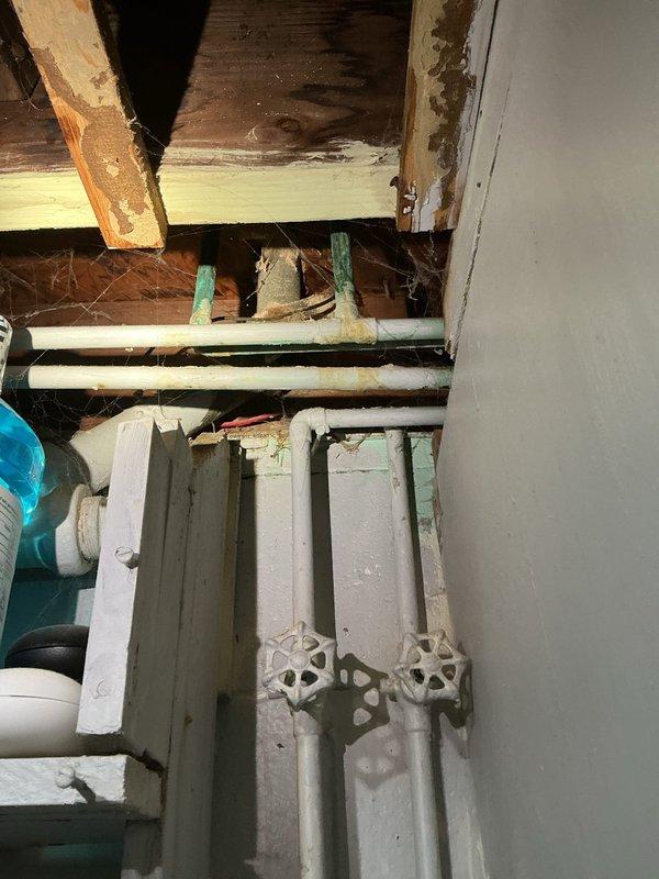 Replaced two deteriorated shut-off valves in bathroom plumbing system. The existing valves showed significant corrosion and rust, compromising their functionality and reliability. Installed new wheel-style shut-off valves on vertical supply lines to restore proper water control and prevent potential leaks. Work completed in utility access area beneath bathroom fixtures.