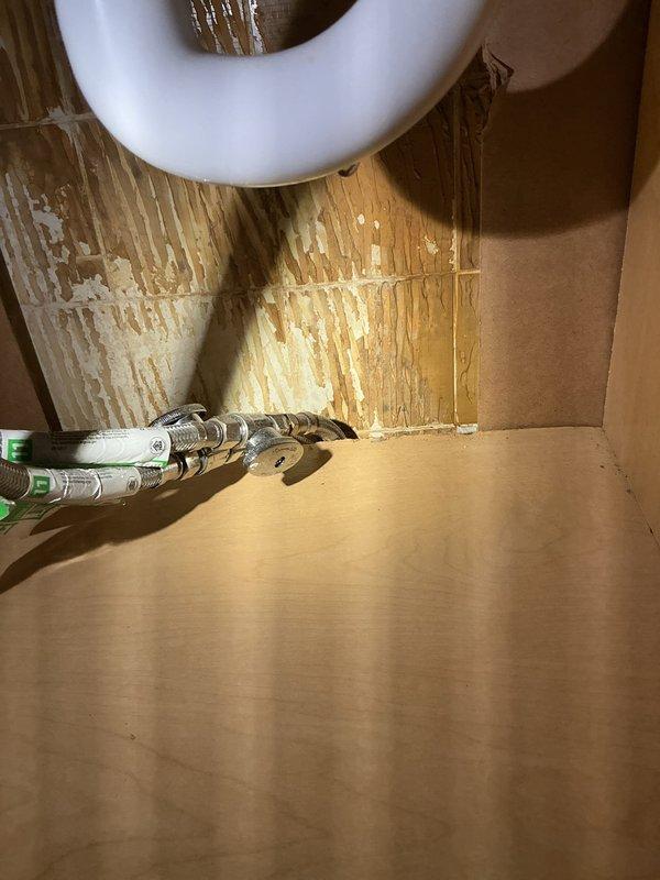 Replaced two deteriorated shut-off valves in bathroom plumbing system. The existing valves showed significant corrosion and rust, compromising their functionality and reliability. Installed new wheel-style shut-off valves on vertical supply lines to restore proper water control and prevent potential leaks. Work completed in utility access area beneath bathroom fixtures.