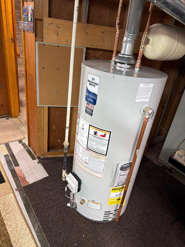 Removed existing 40-gallon water heater and installed new Bradford White 40-gallon gas water heater in basement utility area. Installation included new water shut-off valve, gas shut-off valve, and thermal expansion tank. Connected copper supply lines and gas piping with proper fittings and joints, installed code-compliant venting system, and positioned unit on protective platform. All components installed per manufacturer specifications with 6-year warranty coverage.