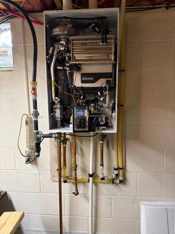 Completed installation of new internal check valve and flow sensor on existing Navien 240a tankless water heater. Accessed internal components of the unit, integrated the flow sensor into the water supply line, and installed the check valve to prevent backflow and ensure proper system operation. All connections were secured with appropriate fittings, electrical connections were made to the control board, and the unit was tested to verify proper flow detection and valve function. The water heater was reassembled and returned to full operational status.