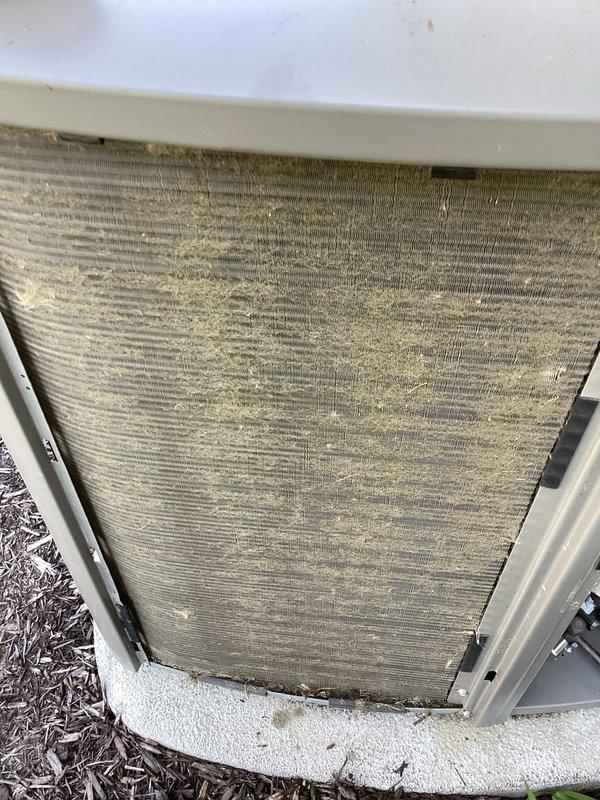 Completed comprehensive AC tune-up service on residential HVAC system. Inspected gas furnace internal components including blower motor assembly, electrical connections, and wiring harnesses; all components found in satisfactory operating condition. Observed moisture staining on concrete floor near furnace base indicating potential condensation drain issue requiring future monitoring. Examined outdoor condenser unit and found air filter severely clogged with dirt, dust, and debris accumulation; filter replacement strongly recommended to restore proper airflow and system efficiency.