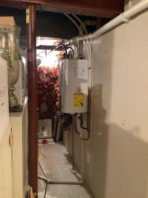 Responded to service call for 3-year-old tankless water heater experiencing intermittent and inconsistent hot water delivery. Upon arrival, performed comprehensive diagnostic evaluation of the unit, including inspection of gas supply lines, water flow sensors, heat exchanger, and electronic control board. Examined copper supply and return piping connections at base of unit for proper flow and pressure. Verified PVC venting system installation and clearances met manufacturer specifications. Assessed unit's operational performance through multiple heating cycles to identify source of inconsistent temperature output. Documented equipment condition and installation configuration with photographic evidence showing Energy Star certified tankless unit with proper mounting, gas and water line connections with shutoff valves, and exhaust venting routed through ceiling. System evaluated for potential issues including mineral buildup, flow rate restrictions, ignition sequencing problems, or flame