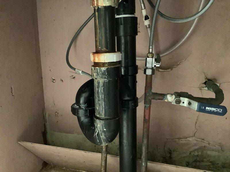 Replaced kitchen faucet with side spray unit and basement shower faucet assembly. The basement installation required replacement of the Central Brass 7223-A fixture due to deteriorated riser pipe that had rotted out. Parts were ordered for will call pickup, and photographic documentation was captured showing the existing conditions of both the kitchen sink area and basement plumbing installation prior to repair completion.