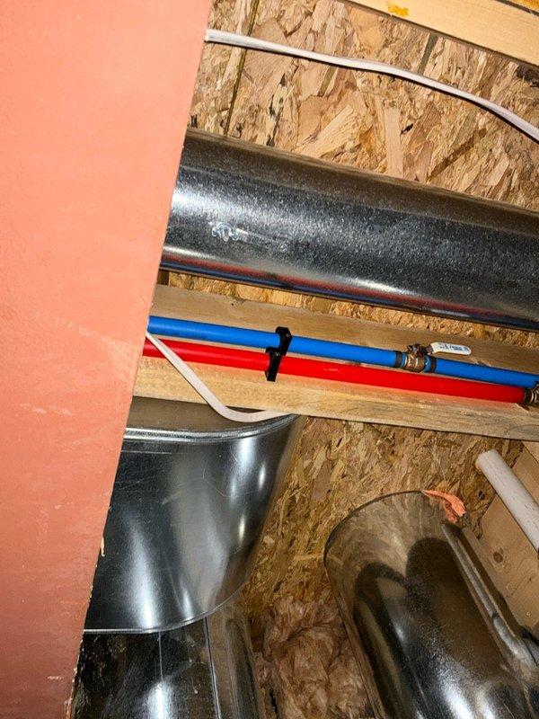 Conducted site assessment for mini split installation in upstairs area. Evaluated existing HVAC infrastructure including ductwork, PEX plumbing lines, and electrical routing through exposed ceiling joists and OSB framing. Documented current mechanical systems layout and identified optimal placement for mini split components based on structural conditions and available space within the unfinished ceiling cavity.