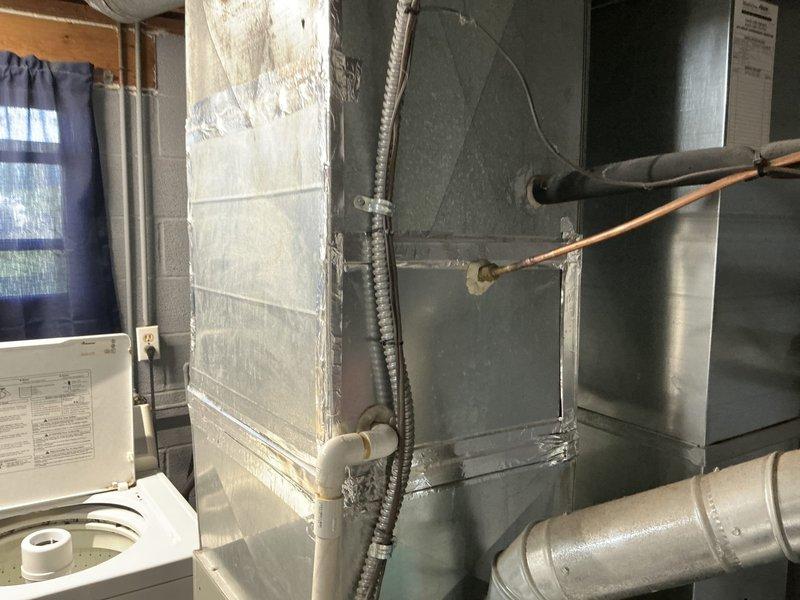 Conducted on-site assessment of existing HVAC system in basement mechanical room to provide replacement estimate. Evaluated current furnace/air handler unit, refrigerant line configuration, ductwork layout, and condensate drainage system. Documented existing equipment conditions including copper refrigerant lines with mounting brackets, flexible corrugated conduit, metallic ductwork with T-junction branching, and PVC condensate drain piping. Photographed installation for accurate equipment specifications and system configuration to prepare comprehensive replacement proposal.