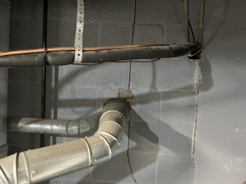 Conducted on-site assessment of existing HVAC system in basement mechanical room to provide replacement estimate. Evaluated current furnace/air handler unit, refrigerant line configuration, ductwork layout, and condensate drainage system. Documented existing equipment conditions including copper refrigerant lines with mounting brackets, flexible corrugated conduit, metallic ductwork with T-junction branching, and PVC condensate drain piping. Photographed installation for accurate equipment specifications and system configuration to prepare comprehensive replacement proposal.