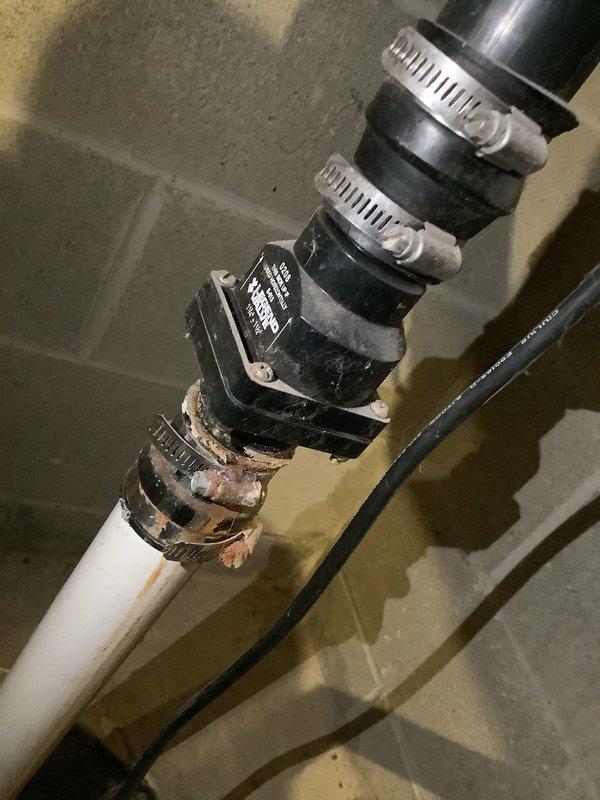 Responded to service call for sump pump making humming noise. Upon inspection, found sump pump motor attempting to run but unable to operate properly. Accessed sump pit and identified mechanical failure preventing pump operation. Removed existing pump assembly and inspected discharge piping system, which included PVC piping connected through rubber fernco couplings and check valve assembly secured with stainless steel hose clamps. Check valve showed proper orientation to prevent backflow. Replaced failed sump pump unit with new comparable model, reconnected electrical wiring, and tested discharge line for proper flow and valve operation. Cycled pump multiple times to verify proper startup, operation, and automatic shutoff functionality. Confirmed no humming noise present and pump operating smoothly under normal conditions.