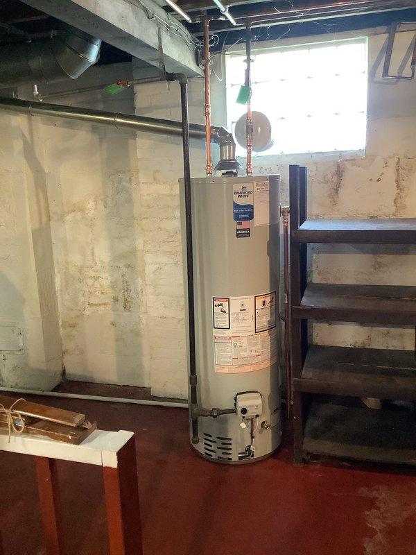 Replaced a failed 40-gallon tall water heater with a new Bradford White 40-gallon tall unit featuring a 6-year manufacturer warranty. Brought installation up to current plumbing code by replacing the cold water shut-off valve, installing a new gas shut-off valve, adding proper bonding wire for electrical grounding, and installing a thermal expansion tank to protect against pressure buildup in the closed water system. All connections were tested and verified for proper operation upon completion.