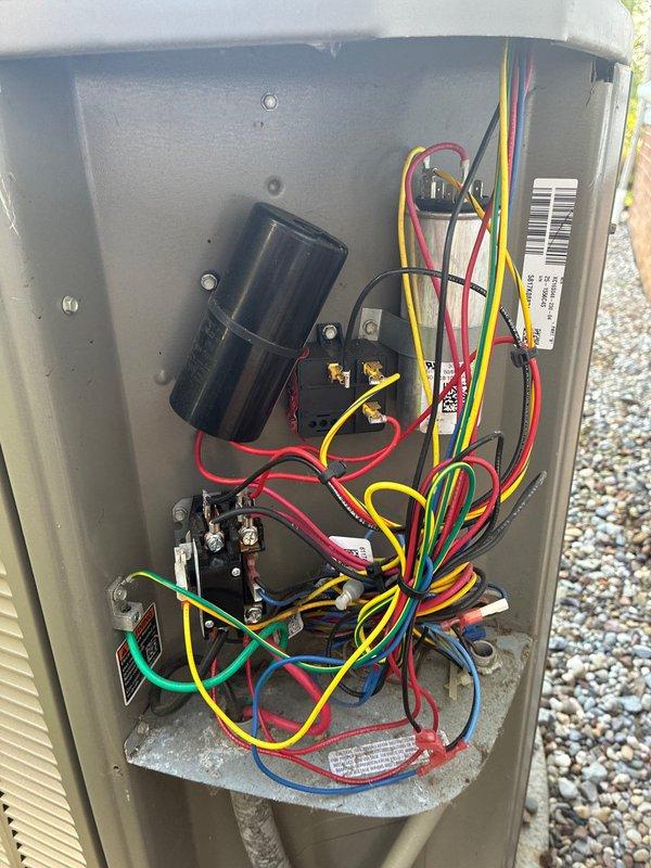 Performed routine air conditioning maintenance visit on 9-year-old Lennox HVAC system for MVP customer. Inspected outdoor condensing unit electrical compartment, verifying proper operation of capacitor, contactors, and relay connections. Documented extensive wiring configuration including power and control circuits. Examined indoor air handler and furnace assembly, checking PVC condensate drainage lines and venting connections for proper installation and functionality. All electrical components, refrigerant connections, and drainage systems found operating within normal parameters.