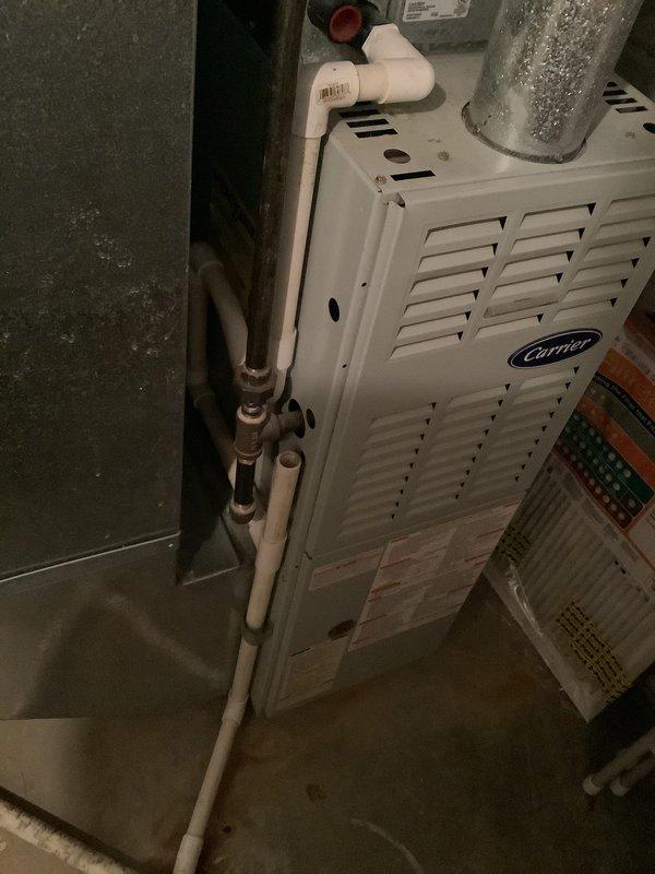 Conducted comprehensive assessment of 28-year-old furnace and air conditioning system at owner-occupied residence for complete replacement estimate. Evaluated existing Carrier furnace installation, inspected condensate drainage lines, venting configuration, and electrical connections in basement utility area. Documented current system condition including aged refrigerant lines showing corrosion, existing ductwork connections, and overall equipment layout to provide accurate replacement specifications and installation requirements.