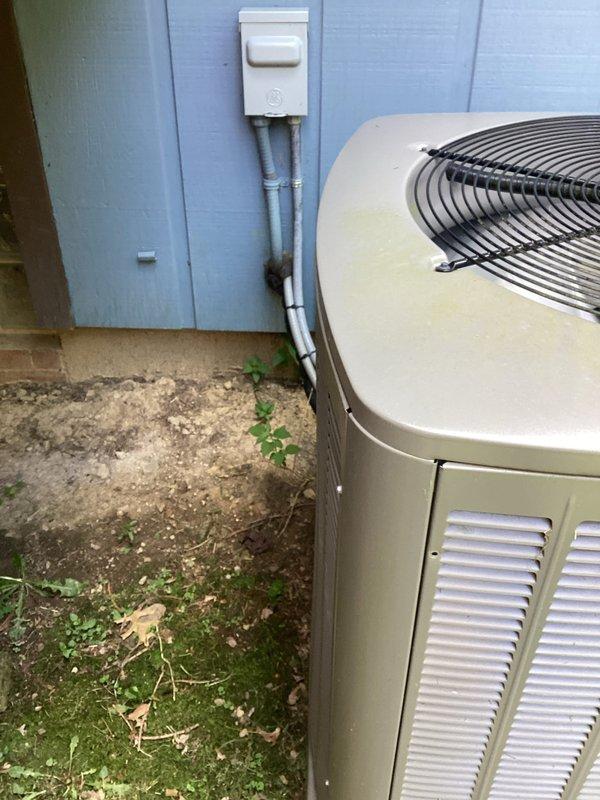 Completed comprehensive A/C tune-up service on residential cooling system. Inspected outdoor condensing unit with operational fan assembly and verified proper electrical connections at disconnect box. Examined indoor evaporator coil assembly, noting mineral deposits and discoloration on humidifier pad requiring future attention, and confirmed drainage system functionality with visible PVC piping connections in proper working order.