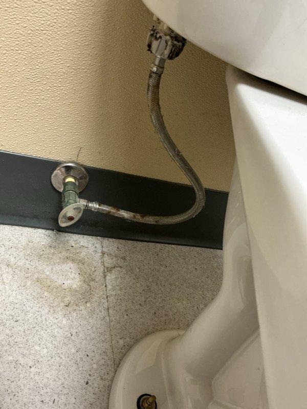 Responded to report of leaking shut-off valve in first stall of ladies restroom. Inspected angle stop valve and braided supply line connection serving toilet fixture. Replaced faulty shut-off valve assembly with new chrome-plated angle stop, installed new braided stainless steel supply line, and tested connections under pressure to verify leak was resolved and proper operation restored.