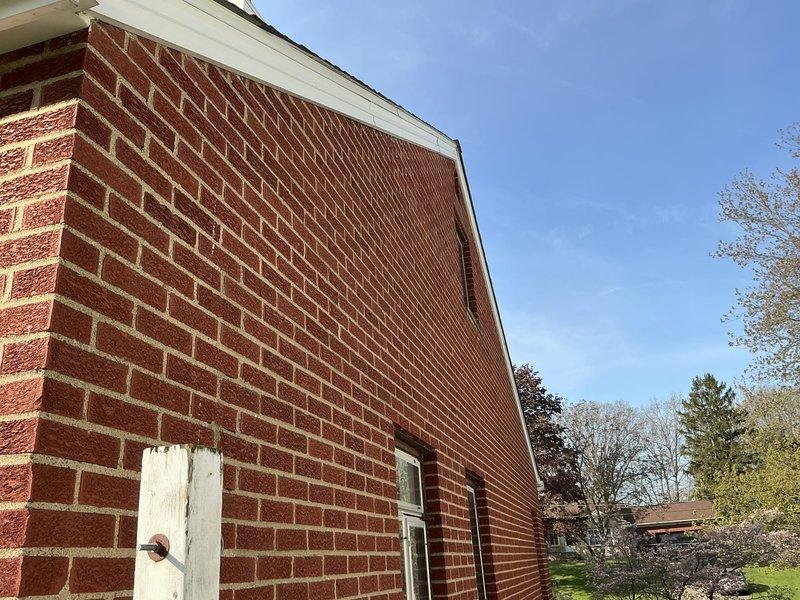 Conducted on-site assessment for mini split installation in attic bedroom space. Evaluated interior room layout, ceiling configuration, and exterior wall access point on brick gable end for potential condenser placement and line set routing.