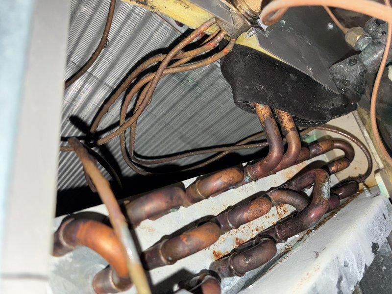 Completed comprehensive AC tune-up inspection on residential HVAC system. Examined evaporator coil assembly, heat exchanger fins, and refrigerant line connections, noting moderate oxidation on copper tubing and accumulated surface debris on internal components. All mechanical components inspected and unit confirmed operational within normal parameters.