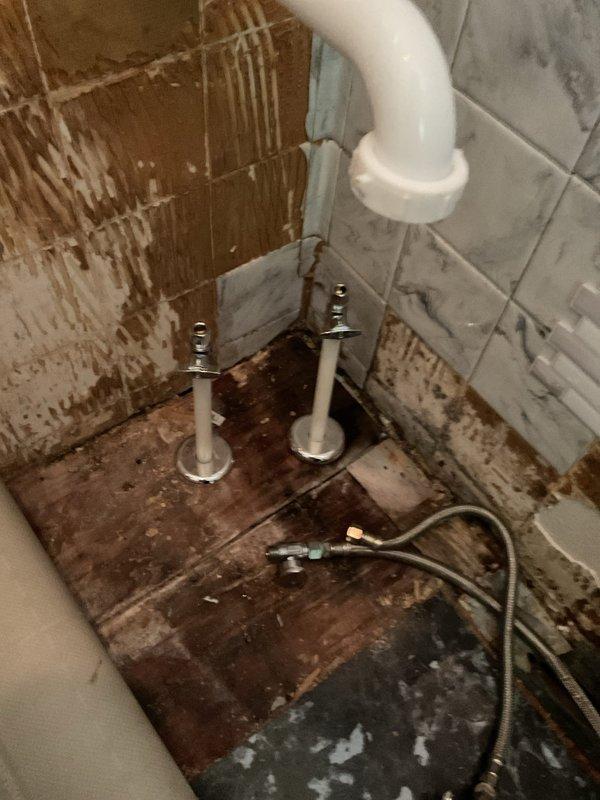 Responded to leaking shut-off valves serving toilet and lavatory in half bathroom. Upon investigation, identified severely corroded water supply lines in basement requiring complete replacement. Removed deteriorated cold water line to toilet by cutting existing pipe from above, cleaned painted surfaces, and installed new PEX water line with new shut-off valve. Replaced both hot and cold water supply lines from basement through floor penetrations into bathroom, stubbing pipes approximately 8 inches above finished floor. Reconnected existing toilet supply line to new plumbing system. All corroded piping successfully removed and replaced with modern PEX distribution system, restoring proper water supply and eliminating leaks at fixture shut-off valves.