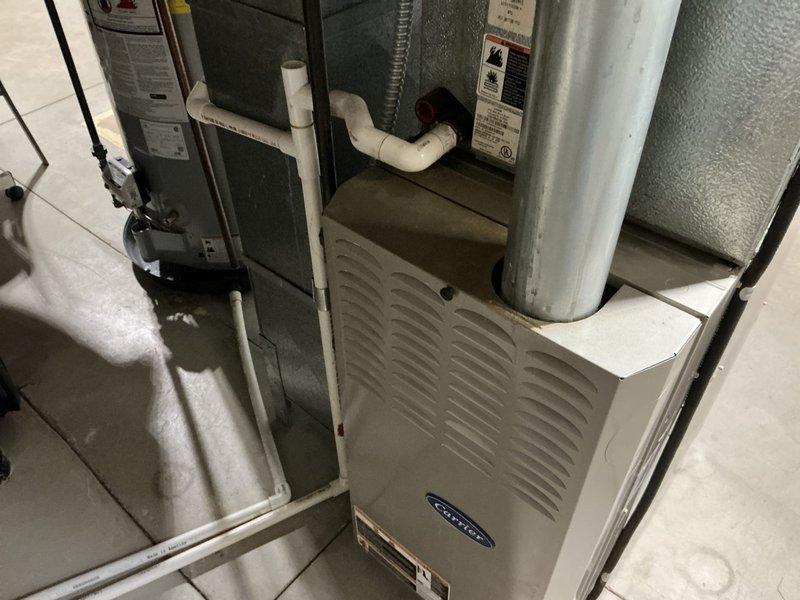 Conducted comprehensive HVAC system assessment and provided replacement estimate for 20-year-old furnace with cracked heat exchanger. Documented existing Carrier furnace installation in basement utility area, including associated ductwork, air handler components, and ventilation systems. Quote prepared for furnace and air conditioning replacement with BOGO promotion, including duct cleaning services, with detailed photographic documentation of current system configuration and heat exchanger failure.