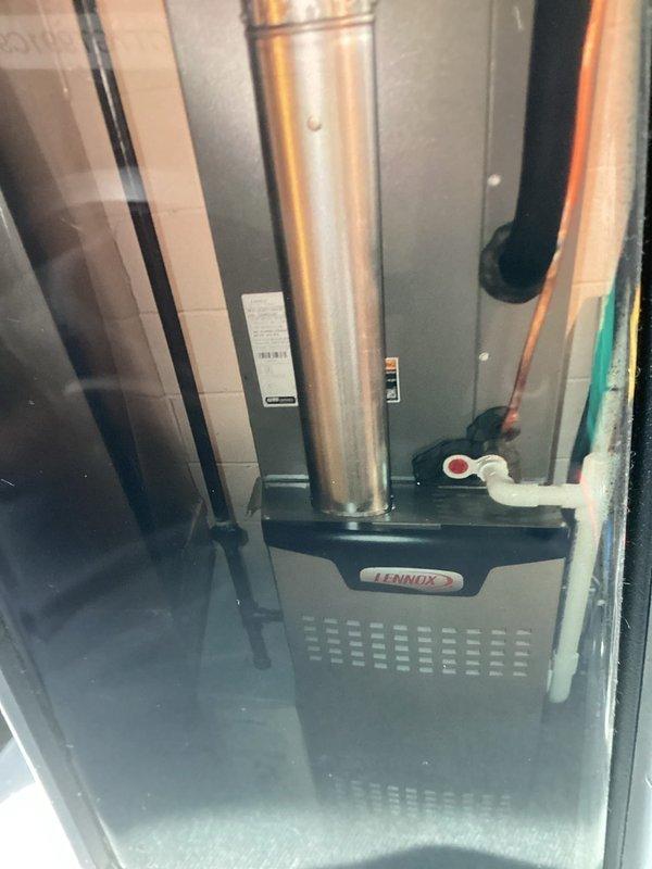 Completed MVP cooling maintenance visit on Lennox HVAC system. Performed standard inspection of furnace unit and air filtration components, documenting equipment condition with photographs. Filter showed moderate discoloration and staining requiring attention, while furnace unit and flue assembly appeared in serviceable condition with proper venting configuration intact.
