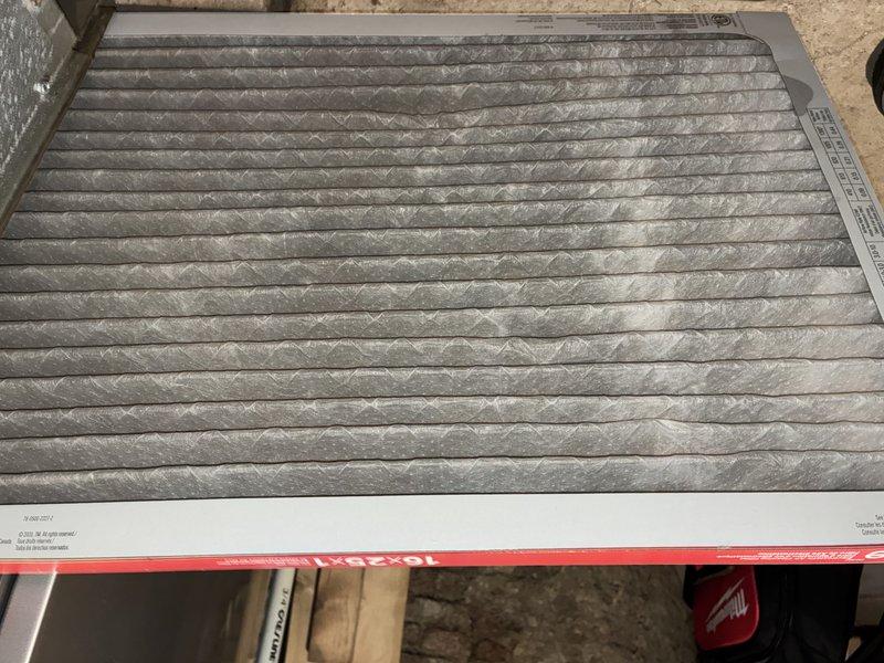 Completed MVP Cooling Visit recurring service maintenance. Inspected AprilAire humidifier unit installed in mechanical space, confirmed proper mounting and operational status with no visible damage or deterioration to equipment. Documented existing air filter condition showing moderate dust and debris accumulation across pleated media, indicating normal usage cycle and proper filtration performance.