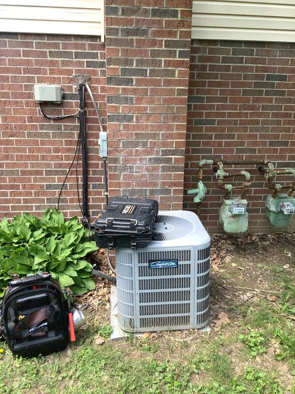 # HVAC Install - A/C & Coil

## Summary
Completed installation of air conditioning system with evaporator coil on second-floor application, including outdoor condensing unit placement and indoor coil integration with existing furnace system.

## Work Performed

Installed new outdoor condensing unit on exterior foundation pad adjacent to existing gas meter infrastructure. Unit positioned on multicolored brick foundation area with proper clearance from building structure and utility connections. Secured condensing unit to pad and verified level installation for optimal compressor operation.

Integrated new evaporator coil with existing gray metal furnace unit in basement utility room. Coil installed in proper airflow orientation within existing ductwork configuration. Connected supply and return air ducts to coil housing, ensuring sealed connections to prevent air leakage and maintain system efficiency.

Ran refrigerant line set consisting of copper suction and liquid lines from outdoor 