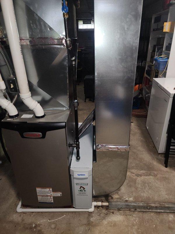 Completed second-stage installation of high-efficiency 90% AFUE furnace system in residential basement. Installed new furnace unit with PVC venting, connected to vertical sheet metal plenum and ductwork distribution system, and integrated AprilAire humidification equipment to provide whole-home comfort control.