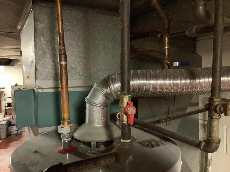 Responded to service call for water heater leak and loss of hot water. Upon inspection, found active leak at tank connection point and determined the tanked water heater had reached end of service life. Removed and disconnected existing failed water heater unit, including all water supply lines, gas connections, and venting components. Installed new tanked water heater with proper clearances and code-compliant connections. Connected cold water supply and hot water outlet lines using copper piping with appropriate shutoff valves. Installed new temperature and pressure relief valve with proper discharge piping. Reconnected gas supply line with new flexible connector and verified all connections for leaks using soap solution. Attached venting system and confirmed proper draft operation. Filled tank, purged air from system, and tested all connections for leaks. Fired unit and verified ignition sequence, burner operation, and proper heating cycle. Adjusted temperature settings to manufactur