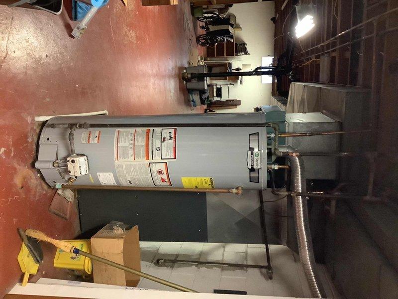 Responded to service call for water heater leak and loss of hot water. Upon inspection, found active leak at tank connection point and determined the tanked water heater had reached end of service life. Removed and disconnected existing failed water heater unit, including all water supply lines, gas connections, and venting components. Installed new tanked water heater with proper clearances and code-compliant connections. Connected cold water supply and hot water outlet lines using copper piping with appropriate shutoff valves. Installed new temperature and pressure relief valve with proper discharge piping. Reconnected gas supply line with new flexible connector and verified all connections for leaks using soap solution. Attached venting system and confirmed proper draft operation. Filled tank, purged air from system, and tested all connections for leaks. Fired unit and verified ignition sequence, burner operation, and proper heating cycle. Adjusted temperature settings to manufactur