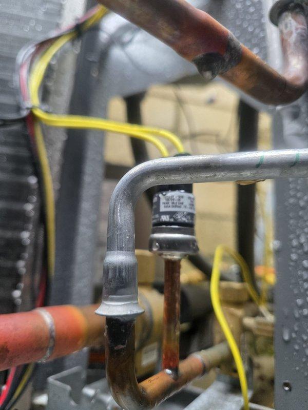 Responded to callback for air conditioning system installed in October that would not operate when first turned on for the season. Upon arrival, conducted thorough system inspection and diagnostic evaluation. Examined indoor unit components including evaporator coil assembly, refrigerant line connections, and control wiring. Verified proper installation of temperature sensors on copper refrigerant lines and checked all electrical connections at control board. Inspected outdoor condensing unit for proper operation and refrigerant circuit integrity. System startup sequence was evaluated, and all safety controls were tested. Documented equipment condition with photographs showing sensor placement on suction line, evaporator coil assembly, and refrigerant piping configuration. Resolved operational issue and verified proper system function with adequate airflow and cooling output.