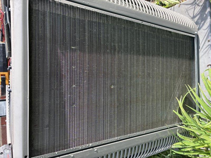Completed scheduled MVP cooling maintenance visit on 4-year-old system. Performed comprehensive inspection of outdoor condenser unit, documenting condition of heat exchanger coils which showed moderate accumulation of dirt, debris, and environmental contamination between fins. Noted visible fin damage including bent, compressed, and corroded sections throughout coil surface, particularly in left-center areas, which may impact airflow efficiency and heat transfer performance. Captured photographic documentation of coil condition showing discoloration, staining, and minor deformation consistent with normal outdoor equipment exposure and operation.