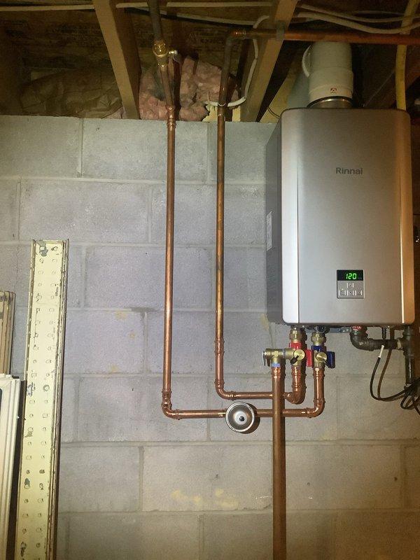 Replaced aging 2006 Rinnai R53 tankless water heater with new Rinnai RE180 non-condensing unit to restore optimal hot water efficiency. Updated and retrofitted all vent piping through roof penetration with proper termination cap, installed new copper water line connections with isolation valves and recirculation loop configuration, and mounted unit on concrete block wall with digital temperature display set to 120°F. All components staged and installed per manufacturer specifications usingNaviRin installation kit, ensuring proper venting, gas connections, and plumbing integration for reliable long-term operation.