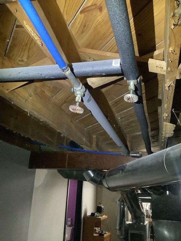 Responded to service call for dripping faucet and utility sink installation request. Upon arrival, assessed existing plumbing infrastructure in basement area near water heater and utility space. Inspected overhead piping system including insulated water supply lines with metal fittings and T-junction connections visible in exposed ceiling joists. Evaluated dripping faucet issue and determined repair requirements. Provided customer with recommendations for new utility sink installation, including optimal placement considerations based on existing plumbing configuration and available workspace in basement utility area.