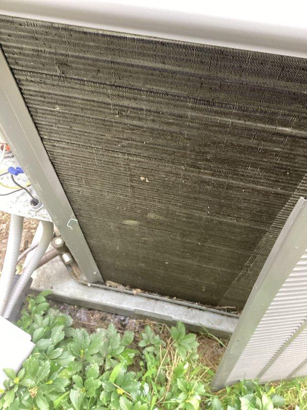 Completed preventive maintenance on 3-year-old residential air conditioning system. Inspected outdoor condensing unit and found heat exchanger coils heavily soiled with dirt, debris, and organic matter accumulation affecting system efficiency. Cleaned condenser coils and removed vegetation growth around unit base. Inspected indoor air handler, verified air filter condition showing clean pleated media with proper airflow. Checked refrigerant lines, electrical connections, and system controls for proper operation. System tested and operating within normal parameters upon completion.