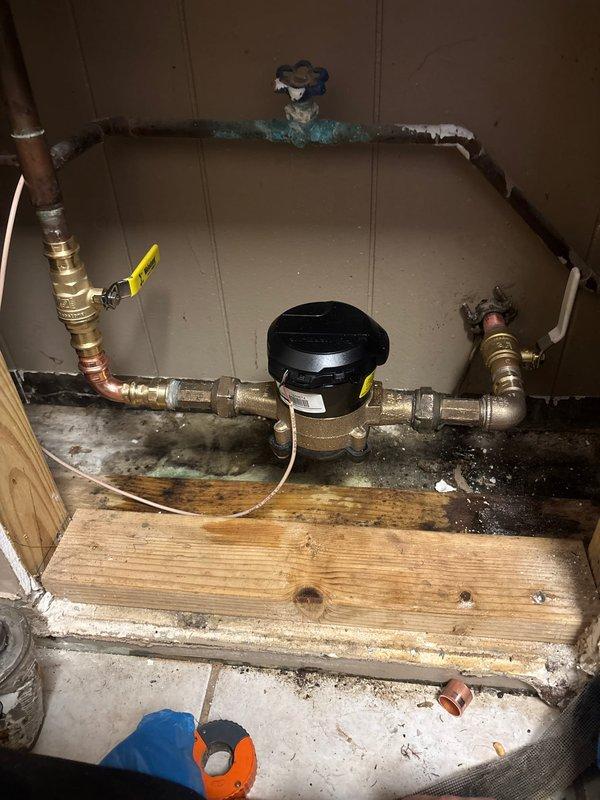 Replaced the main water shut-off valve at the service entry point with a new brass ball valve featuring a yellow handle for improved accessibility and operation. Installed an additional ball valve downstream of the water meter to provide secondary shut-off capability for the building's plumbing system. All copper pipe connections were properly fitted using compression joints and sealed with appropriate thread tape to ensure leak-free operation and compliance with plumbing codes.