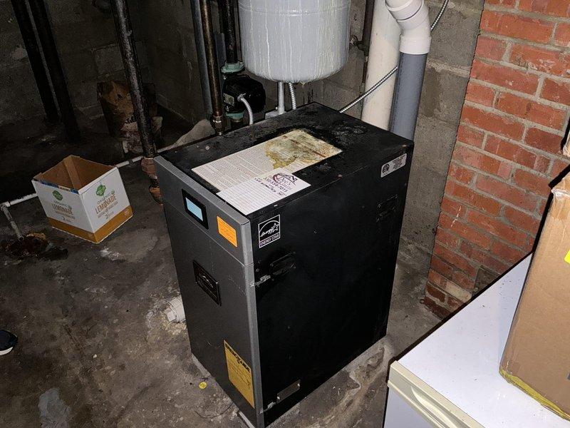 Conducted commercial boiler replacement estimate for aging system experiencing frequent breakdowns and requiring constant repairs. Assessed existing black boiler unit with circulator pump assembly, evaluated current piping configuration including corroded connections and aged metal components, and documented mechanical room conditions. Photographed equipment specifications, Energy Star ratings, pipe connections, and overall system layout to provide comprehensive replacement recommendations.