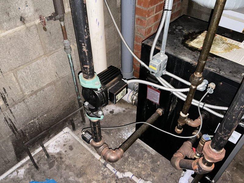 Conducted commercial boiler replacement estimate for aging system experiencing frequent breakdowns and requiring constant repairs. Assessed existing black boiler unit with circulator pump assembly, evaluated current piping configuration including corroded connections and aged metal components, and documented mechanical room conditions. Photographed equipment specifications, Energy Star ratings, pipe connections, and overall system layout to provide comprehensive replacement recommendations.