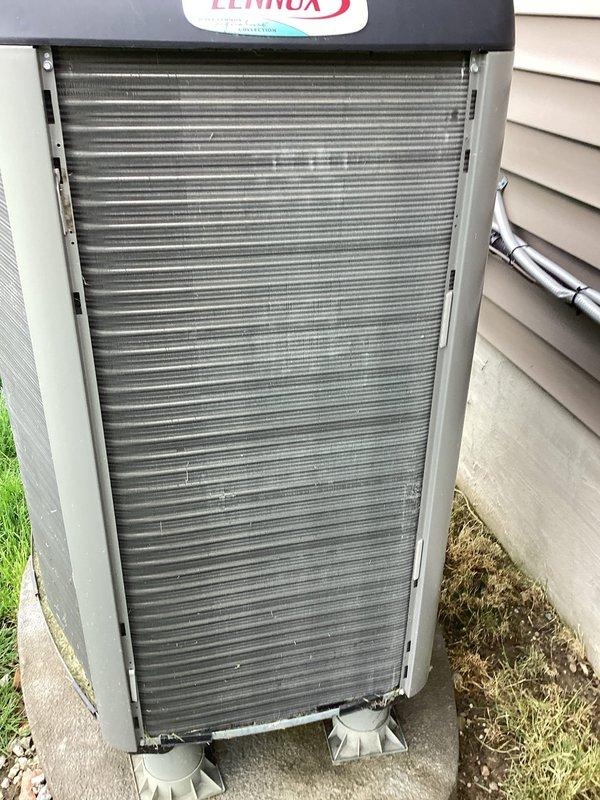 Completed routine BS-MVP cooling maintenance on 4-year-old Lennox air conditioning system. Inspected outdoor condenser unit, verified clean condenser coils and proper clearances, and documented humidifier filter pad condition showing mineral buildup within the air handler. All components photographed and system found operational with no immediate service needs identified.