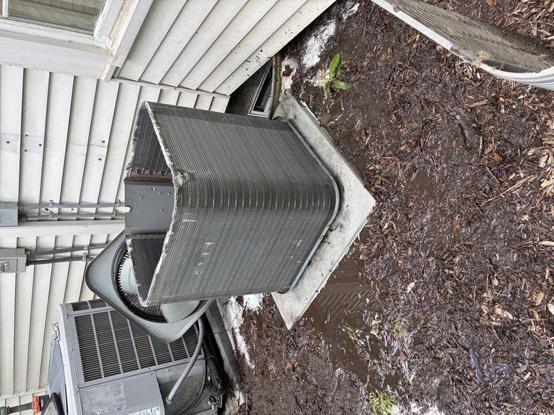 Completed BS-MVP recurring cooling maintenance visit on residential HVAC system. Upon arrival, performed comprehensive inspection of outdoor equipment including triangular A-frame evaporator coil and associated air handler unit. Documented heavy accumulation of dirt, debris, and organic matter on evaporator coil fins, which was significantly restricting airflow and reducing system efficiency. Cleaned and serviced evaporator coil assembly to restore proper heat transfer capability. Inspected flexible ductwork connections and verified proper sealing. Checked concrete pad mounting and equipment positioning. System operational following maintenance procedures.