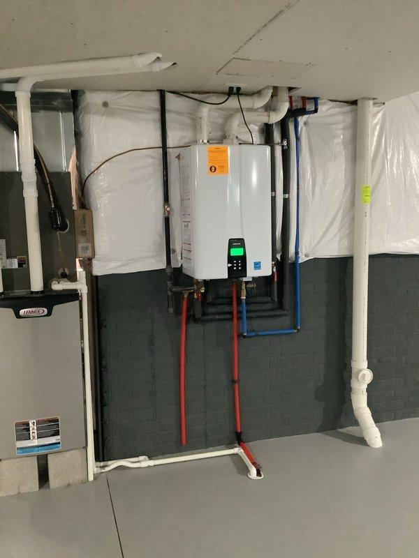 Responded to service call for Navien NPE 240A2 natural gas tankless water heater experiencing intermittent hot water shutoff and displaying PUB board connection error code. Upon arrival, inspected the wall-mounted unit in basement installation and verified error message on digital display. Examined all electrical connections between the primary control board and PUB (Power Unit Board) for loose wiring, corrosion, or damaged connectors. Tested voltage supply to the unit and confirmed proper gas line pressure. Assessed wiring harness integrity and connector seating between boards. Documented existing conditions with photographs showing unit installation, piping configuration including hot and cold water lines, gas connections, and venting system. Relayed diagnostic findings and recommended next steps for PUB board replacement or further electrical diagnostics to resolve the communication error between control components.