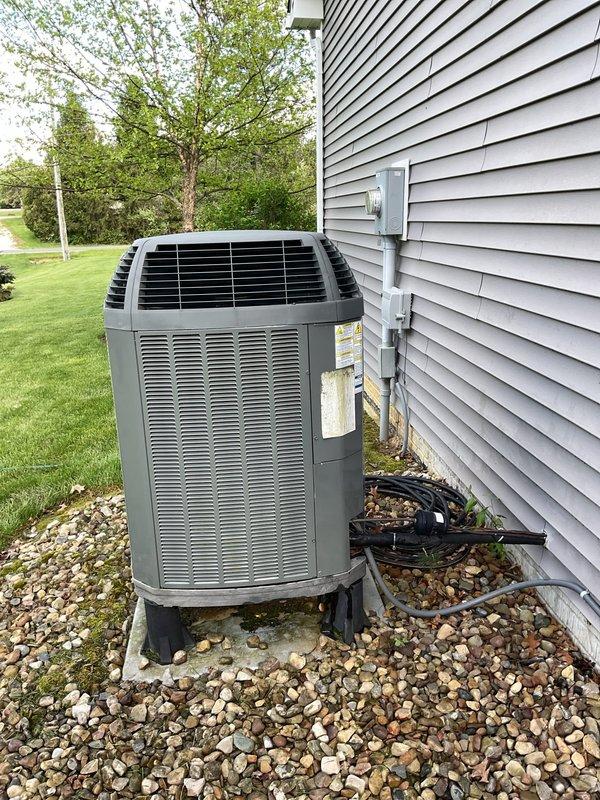 Completed MVP recurring maintenance visit for both heating and cooling systems that had been rescheduled from a previous date. Performed comprehensive inspection and maintenance on outdoor air conditioning condenser unit, including removal of protective grille to access internal components for thorough evaluation. Inspected copper refrigerant lines, coils, electrical connections, and mechanical components for proper operation and wear. Verified electrical disconnect and conduit connections. Assessed unit condition, noting age-related wear and discoloration on copper tubing. Checked concrete pad stability and surrounding drainage area. Reassembled unit upon completion of maintenance procedures. System operational and ready for cooling season.