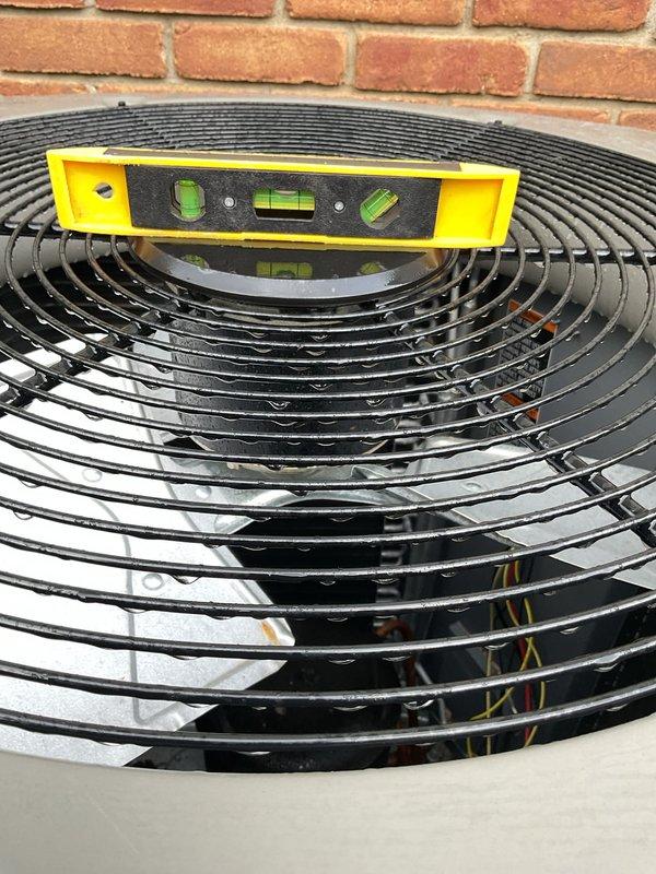 Responded to warranty call for recently installed Lennox air conditioning unit requiring leveling adjustment. Upon arrival, verified unit was unlevel using spirit level on condenser fan grille. Adjusted hexagonal condenser unit positioning on pad to achieve proper level in all directions, ensuring optimal compressor operation and refrigerant flow. Confirmed unit stability on protective pad and verified all refrigerant lines and electrical connections remained secure following adjustment.