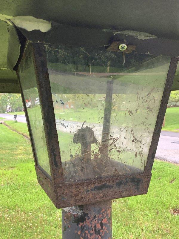 Responded to service call for non-functioning natural gas outdoor light fixture. Upon arrival, inspected gas meter assembly and traced gas line to exterior lantern-style light mounted on post. Found heavily corroded gas piping throughout the system, with extensive rust on valves, connections, and fittings at meter location. The outdoor light fixture exhibited severe deterioration with rusted metal frame, heavily soiled glass panels, and accumulated debris inside the enclosure indicating extended exposure without maintenance. Assessed the gas supply line integrity and connections leading to the fixture. Performed necessary repairs to restore proper gas flow and functionality to the outdoor gas light, ensuring all connections were secure and system was operating safely per code requirements.