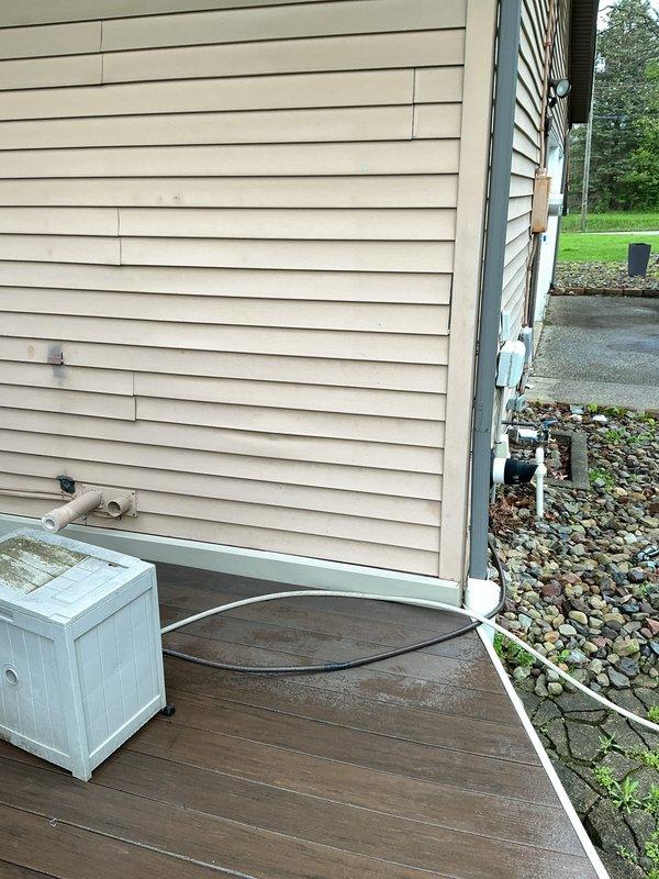 Performed scheduled maintenance flush on tankless water heater system located in basement utility area. Inspected gas line connections and verified proper operation and safety of all components. Documented equipment condition and exterior utility connections with photographic records showing PVC venting system and basement mechanical infrastructure.