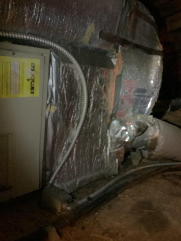 Completed replacement estimate for attic-mounted air handler system in residential property with existing boiler heating configuration. Accessed confined attic space using step ladder to assess current HVAC equipment, documented existing air handler unit showing age-related wear and dust accumulation, evaluated structural framing and clearances for replacement installation, and photographed mechanical components including flexible ductwork connections and electrical wiring routing. Provided comprehensive equipment replacement recommendations based on observed conditions and compatibility with existing boiler heating system.